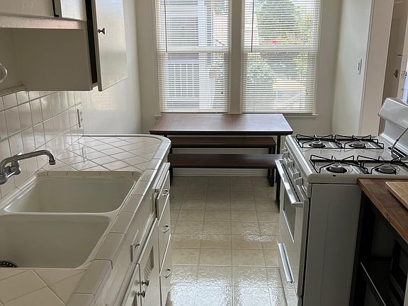 Kitchen w/ gas stove, fridge, and microwave. Previous tenant left a small table and chair in the kitchen nook area