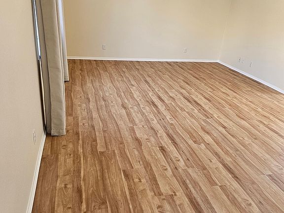 View of the living room from the front door and stairway. Note the new flooring.