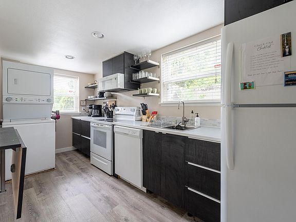 Galley kitchen with full sized refrigerator, dishwasher, oven, glass top electric stove. In unit washer/dryer