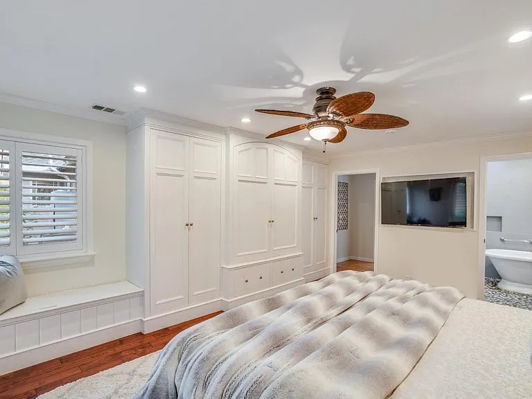 Master bedroom with custom built-in closet cabinetry and storage bench