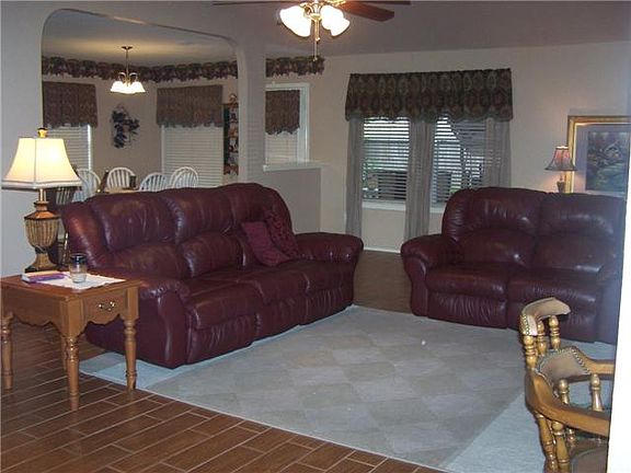    Family room with ceramic wood floor and large window that looks onto outdoor living area.The window treatments remain.