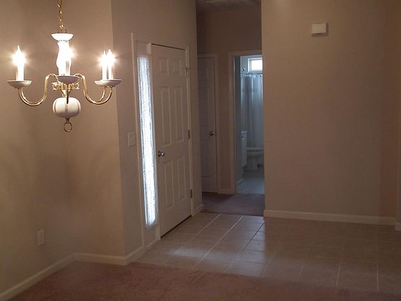 Dining room looking past front door into hall leading to fir