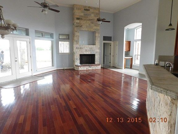 Family room and dining area with stone fireplace and small desk from breakfast area. French doors access to patio and back yard.