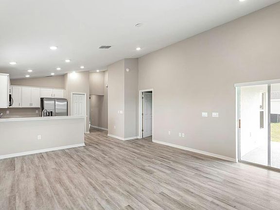 Enjoy a welcoming, open-concept living area with airy volume ceilings - Aurora by Highland Homes