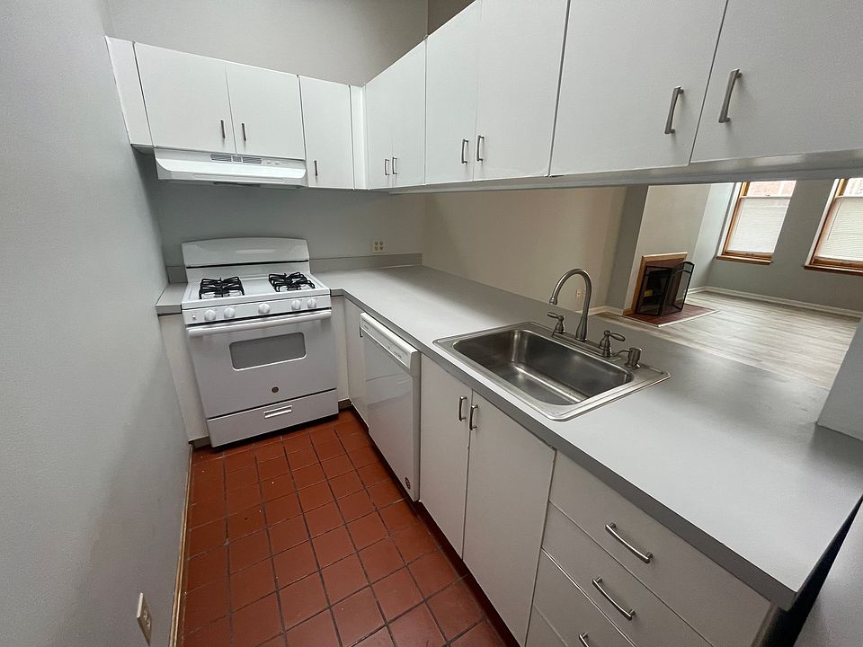 Kitchen with gas stove and plenty of cabinets. Opens to the living room with breakfast bar.