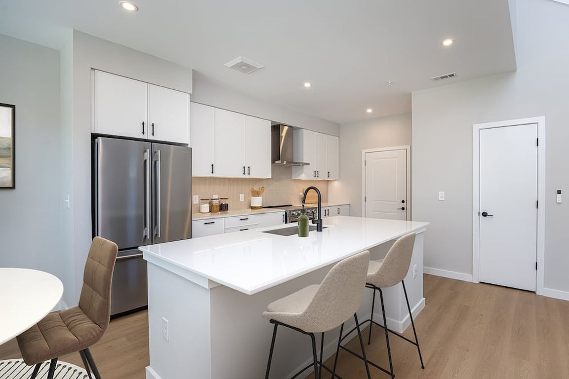 Upgrade Collection 3BR Townhome Kitchen with white cabinetry, white quartz countertops, and over-the-range hood