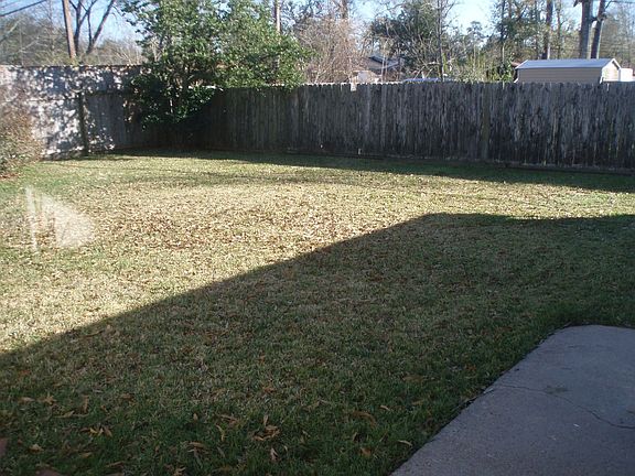 Fully-fenced backyard with patio area, perfect for pets and grilling.