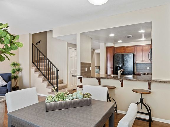 Stylish open-concept apartment with modern kitchen, cozy living space, and elegant staircase.