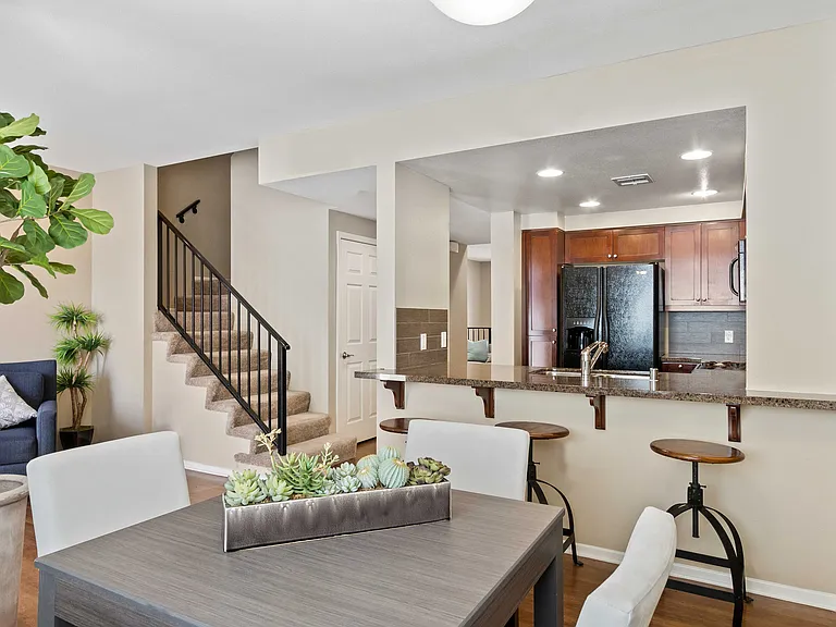 Stylish open-concept apartment with modern kitchen, cozy living space, and elegant staircase.