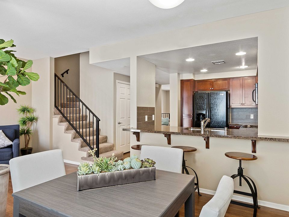 Stylish open-concept apartment with modern kitchen, cozy living space, and elegant staircase.