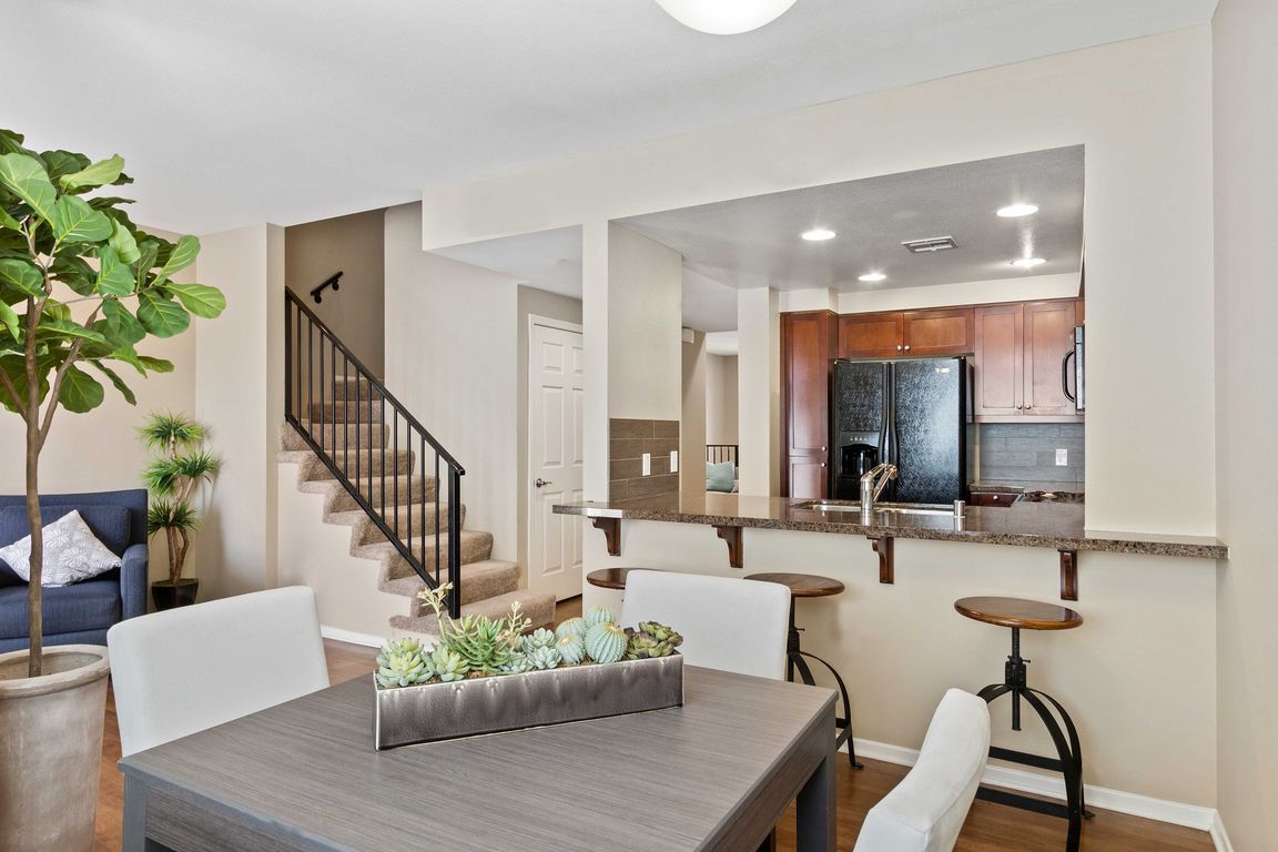 Stylish open-concept apartment with modern kitchen, cozy living space, and elegant staircase.
