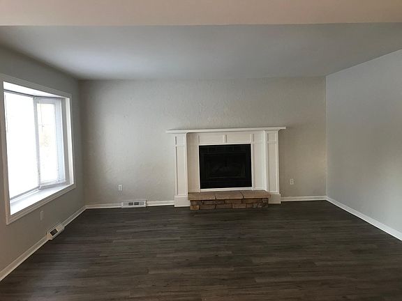 Living Room with bay window and new mantle surrounding the gas fireplace.