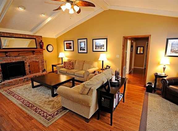 Large great room offers a vaulted ceiling with exposed beams