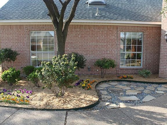 Nicely Landscaped Front Flower Beds with Flagstone and Rock Sitting Area