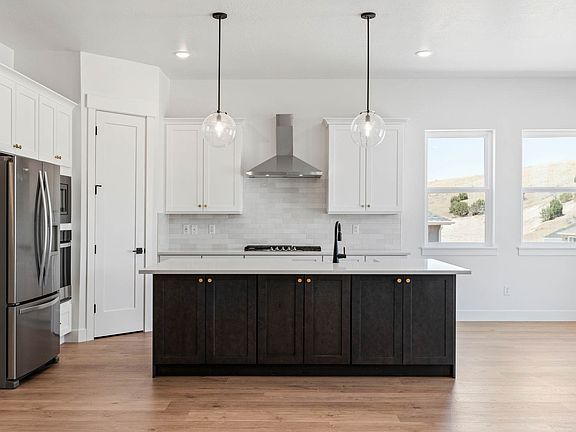 The kitchen has white wood cabinets, quartz countertops and energy-efficient appliances.