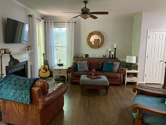 View of living room, from kitchen. Includes gas fireplace and views to the backyard.
