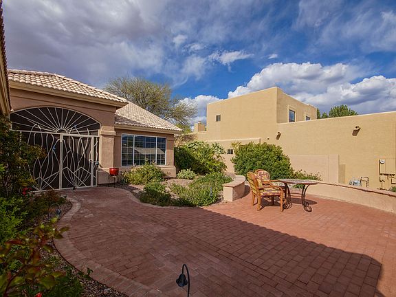 View of front of home with seating area in courtyard