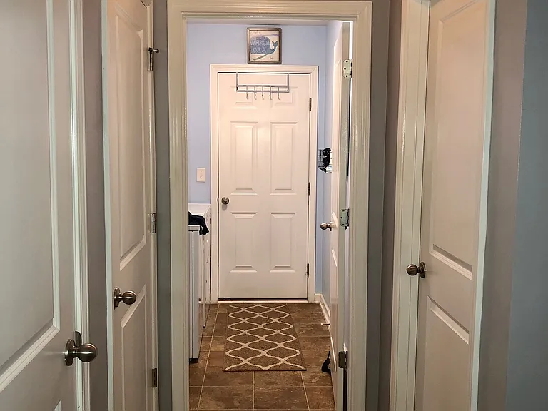 View from hallway bathroom with closet doors on the left & bedroom door on the right