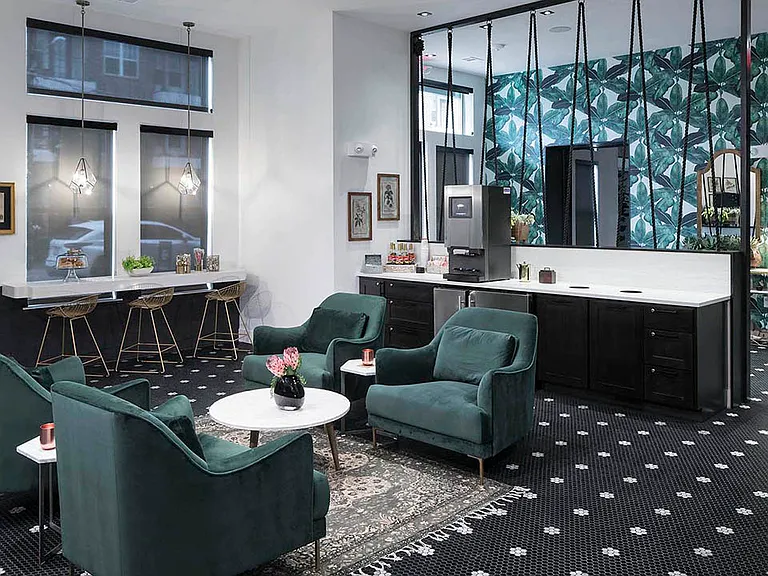 Hospitality area with coffee machine, floral tile floors, and plush seating.
