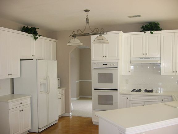 Bright Open Kitchen with Double Ovens White Corian Counter Tops 
