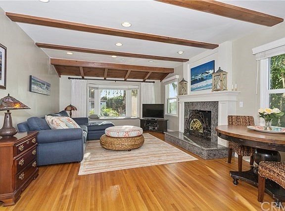 Living room with raised hearth granite fireplace and dining area are an invitation to relaxation and comfort.