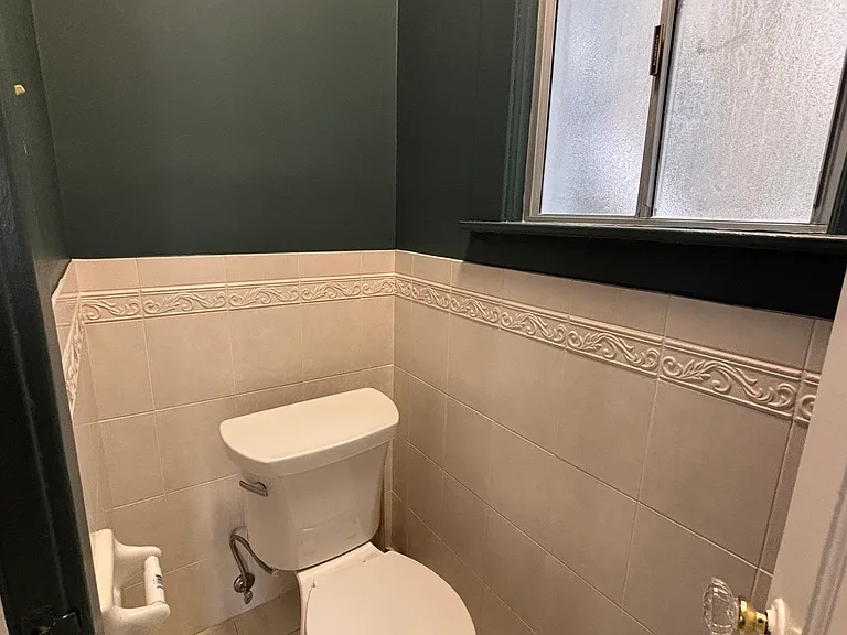 Half bathroom in the hallway, across from the kitchen