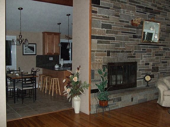 Living room w/granite wall fireplace & Cathedral ceiling