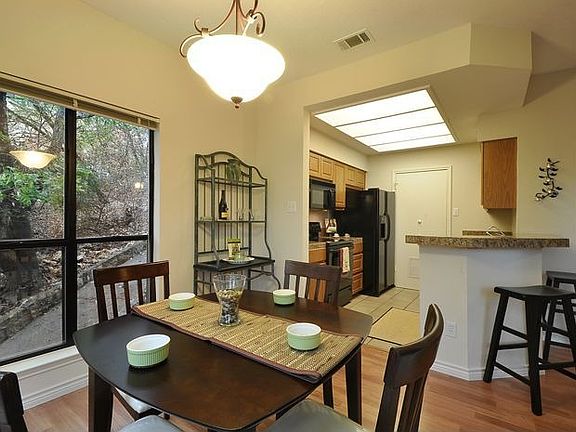 Dining room is surrounded by windows. Great light, natural setting