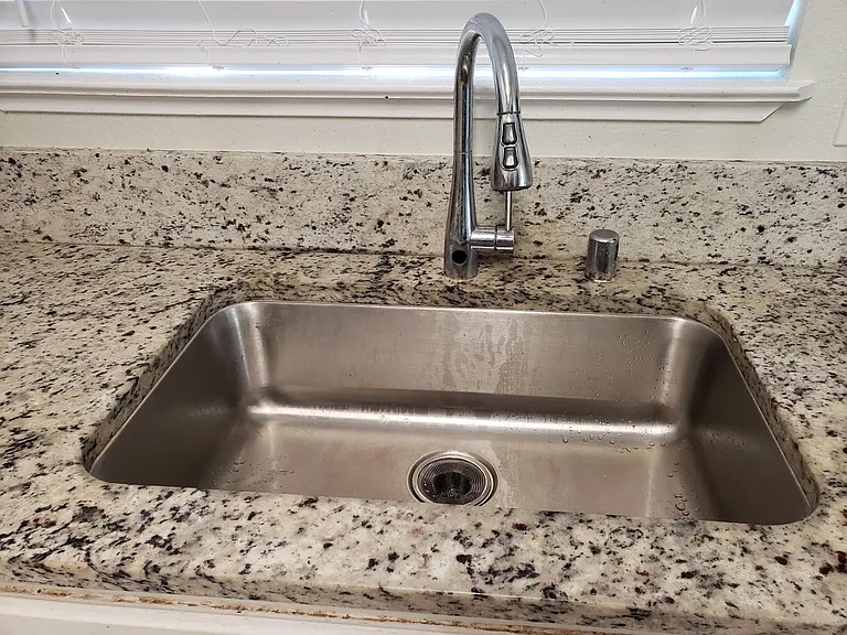 Granite counter top, faucet and steel sink.