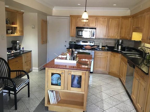 Alternate view of kitchen featuring dedicated desk/work station, large granite island, and separate "back door" entry.