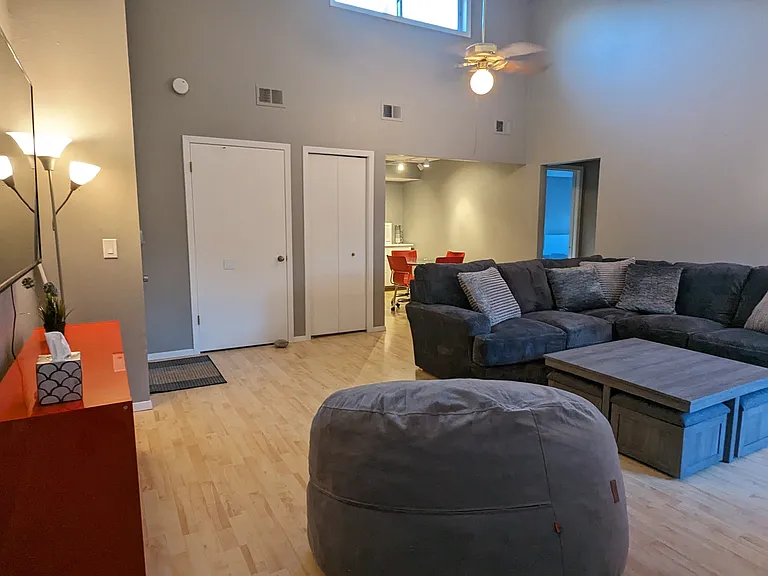 Living room with large couch, coffee table, and wall-mounted TV.