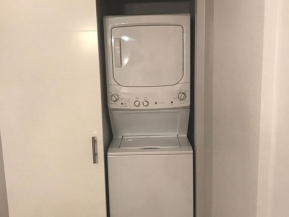 Downstairs stacked washer/dryer with barn door