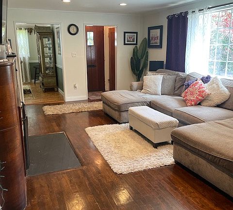 Living room with wood burning fireplace and view of front patio