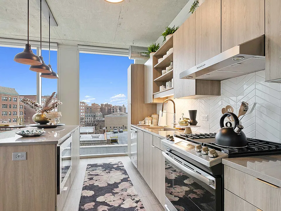 Sleek finishes, a generous island, and stainless steel appliances create a contemporary kitchen designed for easy meals, casual gatherings, and everything in between.
