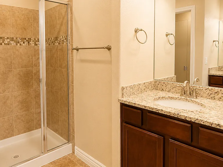 En suite bath with dual facing vanities, walk-in shower, and a separate water closet.