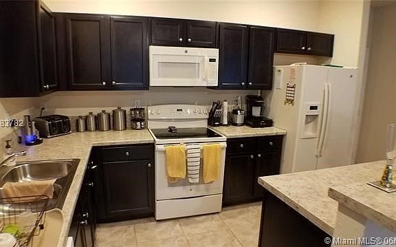 Granite counter kitchen fully equipped and a breakfast bar.