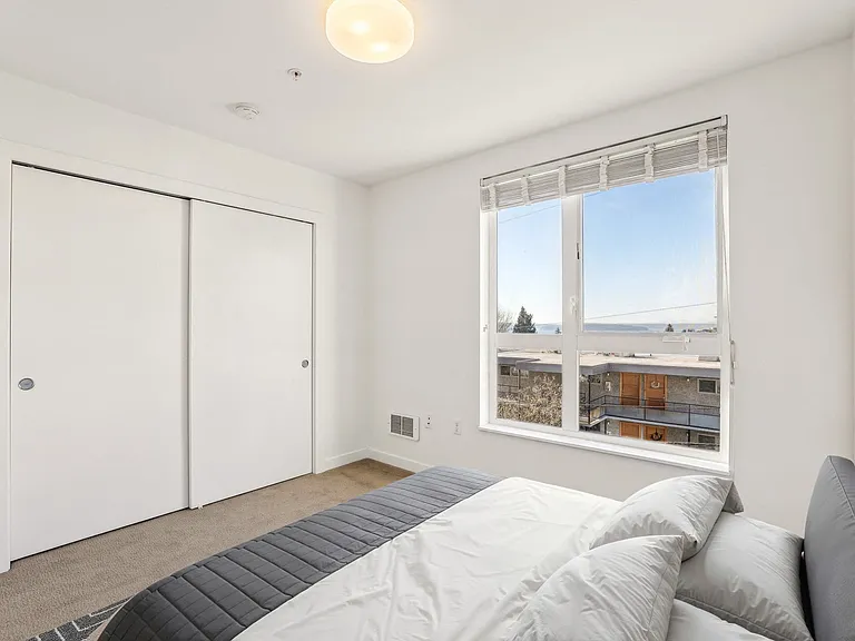 A second bedroom with generous closet space and a peek of the Sound.