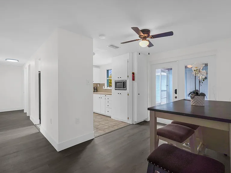Open dining nook beside the kitchen, with a breakfast table, ceiling fan, and sliding glass doors for easy patio access.