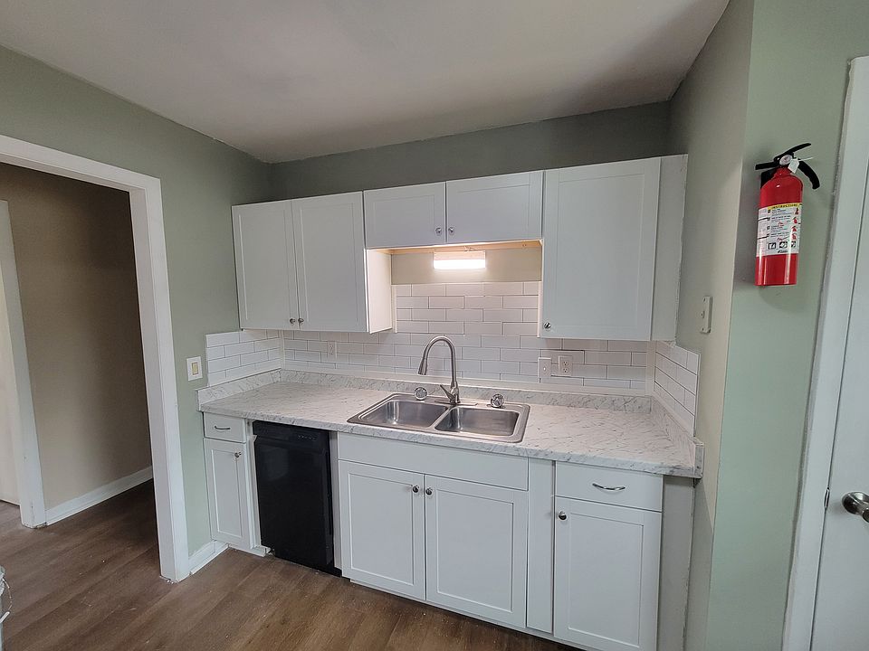 Kitchen with new cabinets, countertops, dishwasher, tile backsplash, & lighting