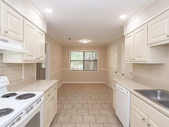 View of kitchen looking toward dining area under windows. Room for large dining table.