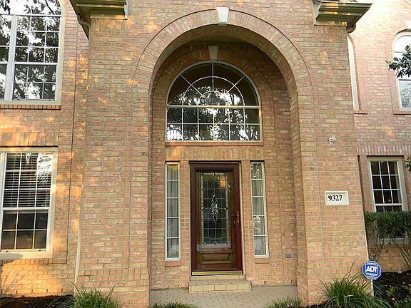 Stunning view of arched entry with leaded glass wood door.