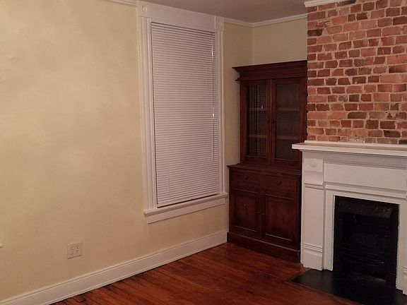 Living room with built-in bookcase and fireplace with exposed brick
