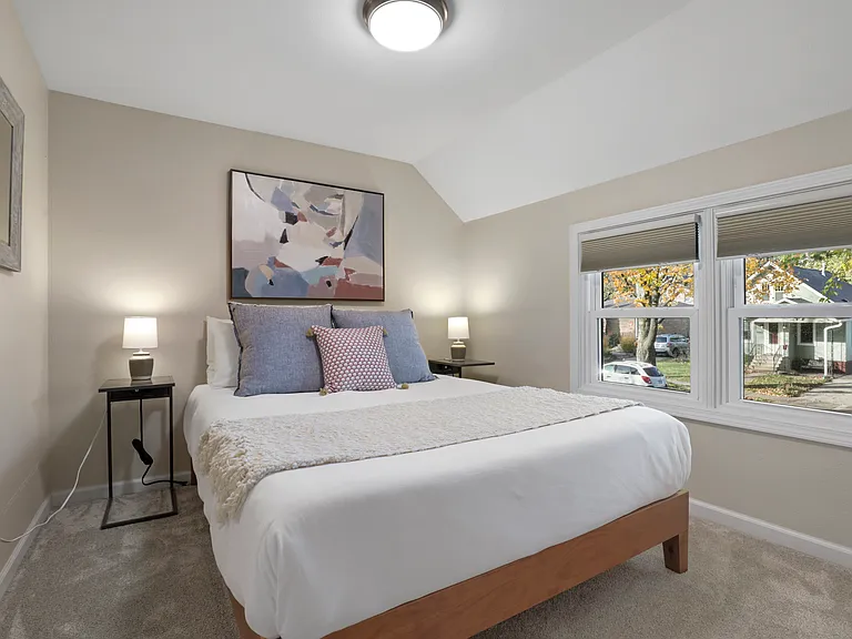 Queen bed with black out blinds, changing mirror, closet with shelving and hanger space.
