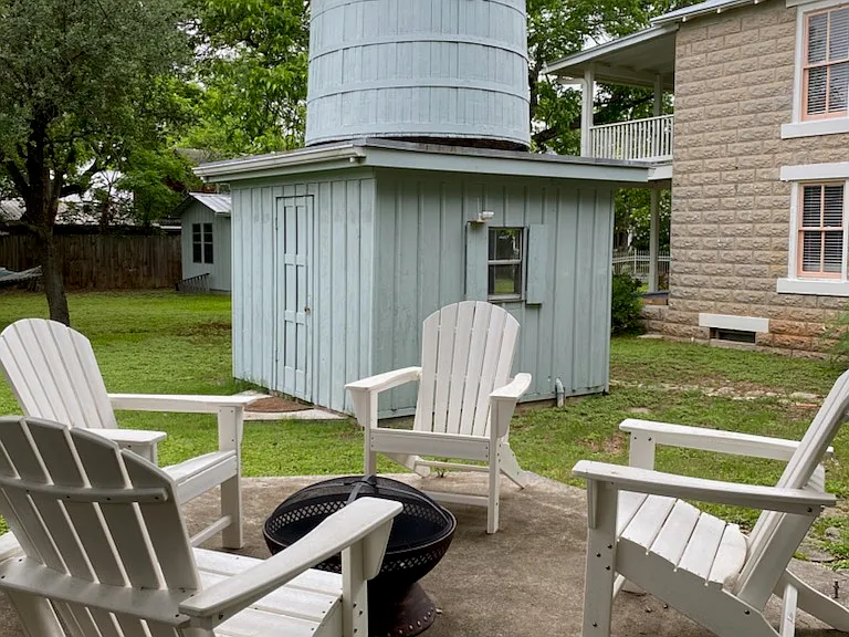 Adirondack chairs circle the pit...check out that tank house!