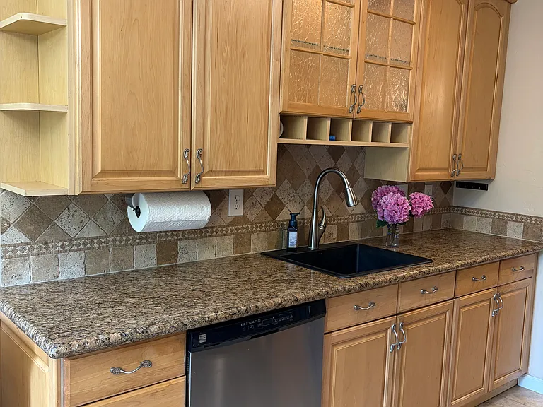 Beautifully upgraded galley kitchen - granite tops, all stainless steel appliances. Custom wine rack and end cap racks. Illuminated cabinet and black designer stone sink. Dishwasher. Brand new gas stove, microwave and refrigerator. Custom chandeleiir.