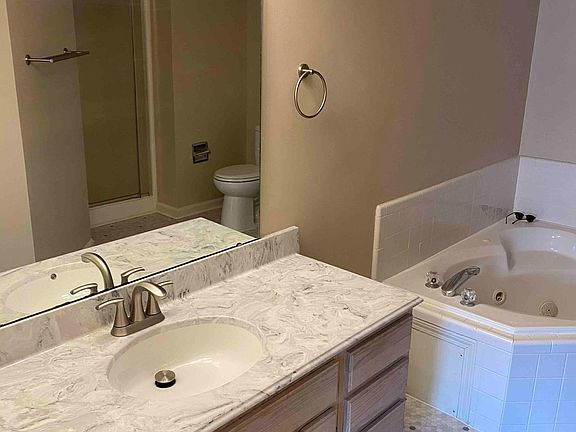 Master Bathroom with new flooring, new countertops, faucets and jacuzzi bath.