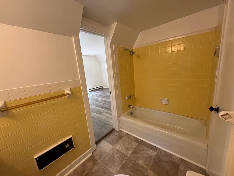 Bathroom. Open door to the primary bedroom. Closed door on the right goes to the kitchen.