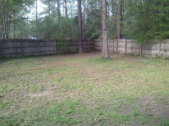 The backyard, is large, flat, and fenced in