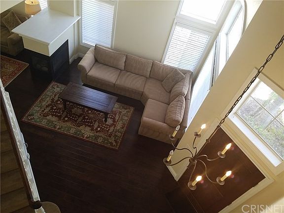 Spacious living room and family room with high ceilings separated by 3-way fireplace.