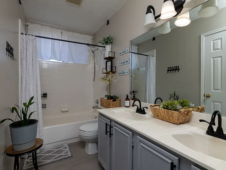 Modern full bathroom with double vanity and tub-shower combo.